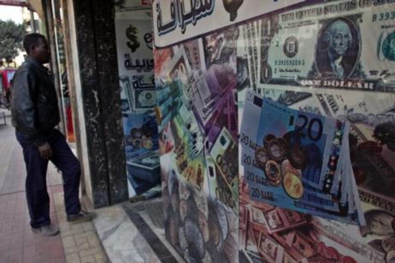 A man walks next to a currency exchange office in downtown Cairo, Egypt, Wednesday, Jan. 2, 2013. The Egyptian pound slid nearly 1 percent last Monday, bringing the exchange rate at banks to 6.42 pounds to the dollar. It marked a cumulative loss of nearly 4 percent this week, after Egypt's central bank took steps in what bankers believe is an attempt to control the devaluation of the currency. (AP Photo/Khalil Hamra) *** Local Caption ***  Mideast Egypt Economy.JPEG-04e74.jpg