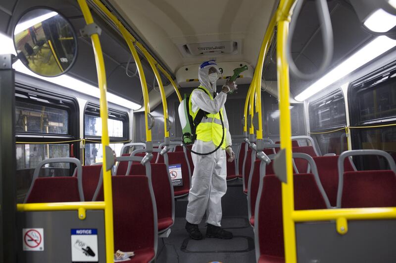 A worker wearing protective suits sprays disinfectant inside a Toronto Transit Commission (TTC) bus in Toronto, Ontario, Canada. The TTC carried about 1.7 million passengers per day prior to the coronavirus pandemic but ridership has sunk by about 80% as people avoid public transportation and work from home. Bloomberg