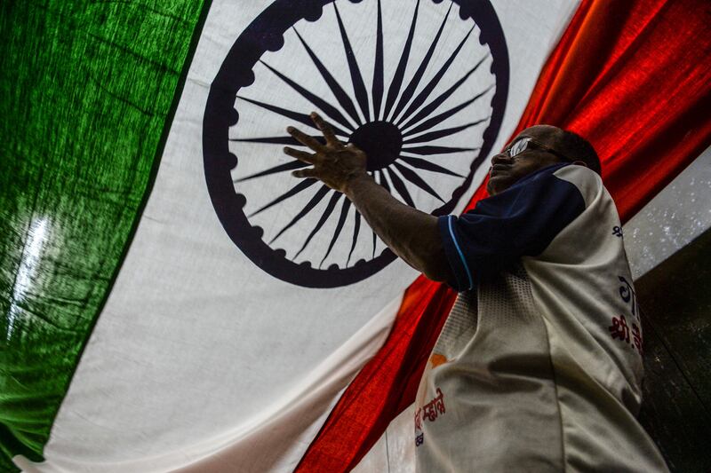 A worker at a workshop in Mumbai inspects a national flag ahead of India's 75th Independence Day celebrations.