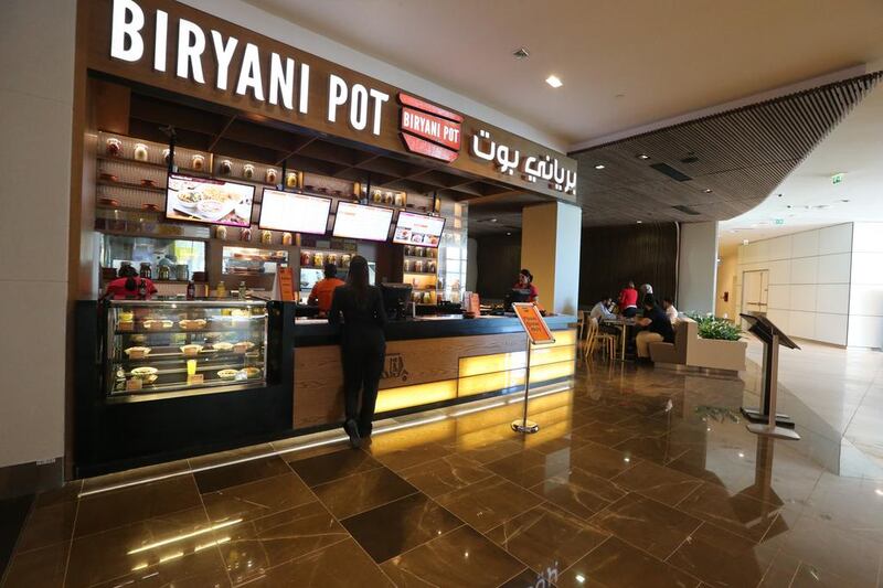 Biryani Pot’s sit-down space is dotted with cream couches and formica furniture. Fatima Al Marzooqi / The National 

