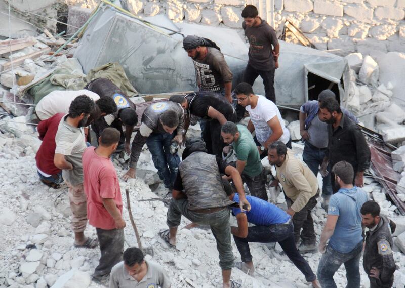 Residents and members of the Syrian Civil Defence, also known as White Helmets, search for victims amid the rubble of a building following a reported air strike in the northwestern town of Harim in Idlib province, on September 29, 2017.  / AFP PHOTO / Omar haj kadour