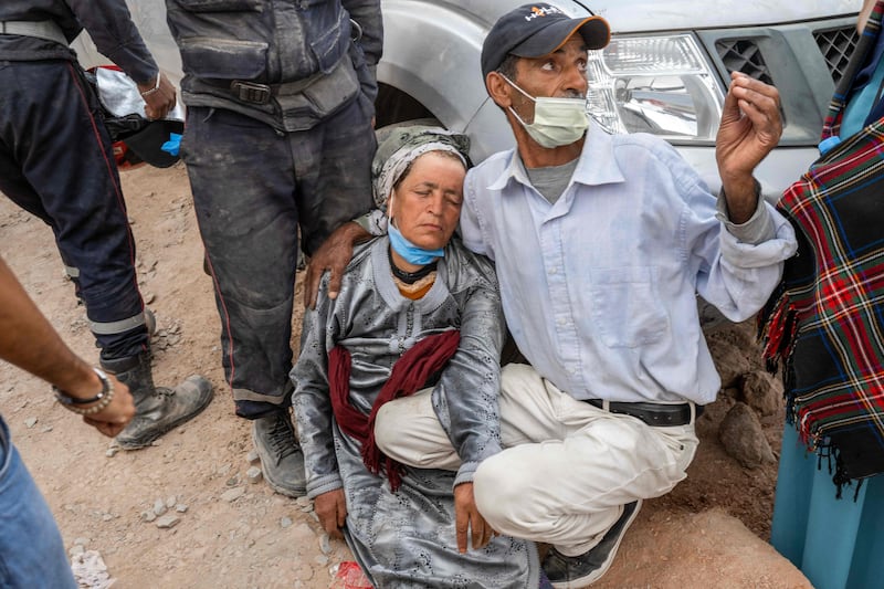 A man consoles a grieving woman in Imi N'Tala, Morocco, after rescue workers recovered the bodies of her relatives from beneath rubble. AFP