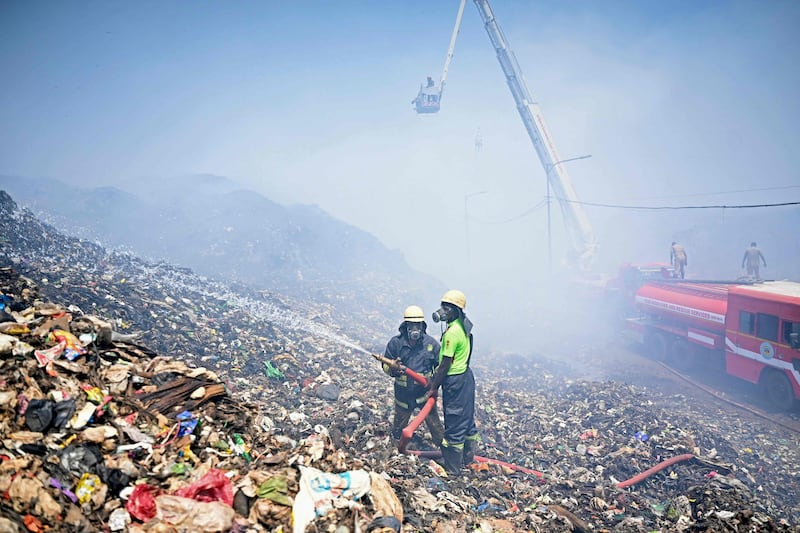 Firefighters try to extinguish burning rubbish after a blaze broke out at the Perungudi landfill site in Chennai. AFP