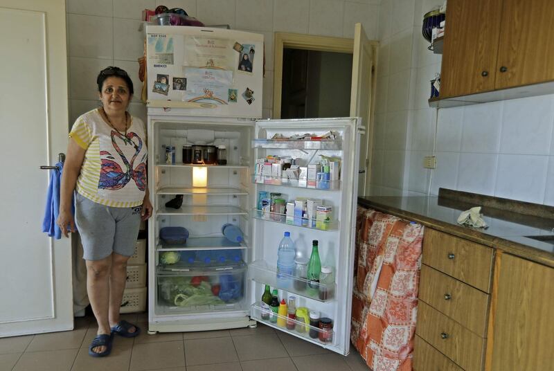 A Lebanese woman displays the content of her refrigerator at her apartment in Byblos. AFP