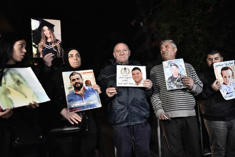 Relatives with portraits of victims of the 2020 Beirut port blast protest outside the residence of Ghassan Oueidat in Baabda, Lebanon, on Wednesday. AFP