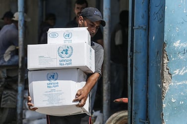 A Palestinian man transports boxes of food outside an aid distribution centre run by the United Nations Relief and Works Agency (UNRWA) in the central Gaza Strip refugee camp of Bureij. AFP
