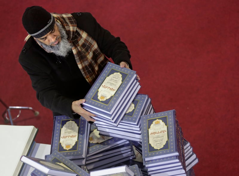 A man selects a series of religious books at the annual Cairo International Book Fair. AP