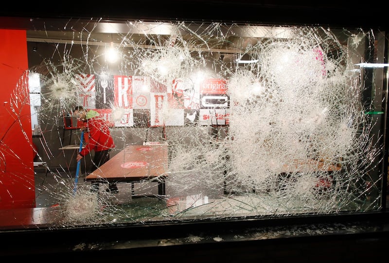 A man cleans up the damage caused by protesters a fast-food restaurant in Rotterdam. AP Photo