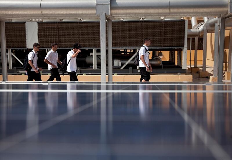 Abu Dhabi, United Arab Emirates, June 230, 2013: 
Invited by the Emirates Solar Industry Association in conjunction with Dubai Municipality, students from Dubai's Jumeirah Baccalaureate School, who are working on a solar power project, listen in to the instruction while they visit a solar installation on Sunday, June 23, 2013, on the roof of the new Al Fahidi Souk in Dubai. The permanent installation is comprised of 139 panels, of which 34 feed the power into OPZv gel batteries to store for the souk, will feed power into the SEWA grid.
Silvia Razgova / The National



 *** Local Caption ***  sr-130623-solar26.jpg