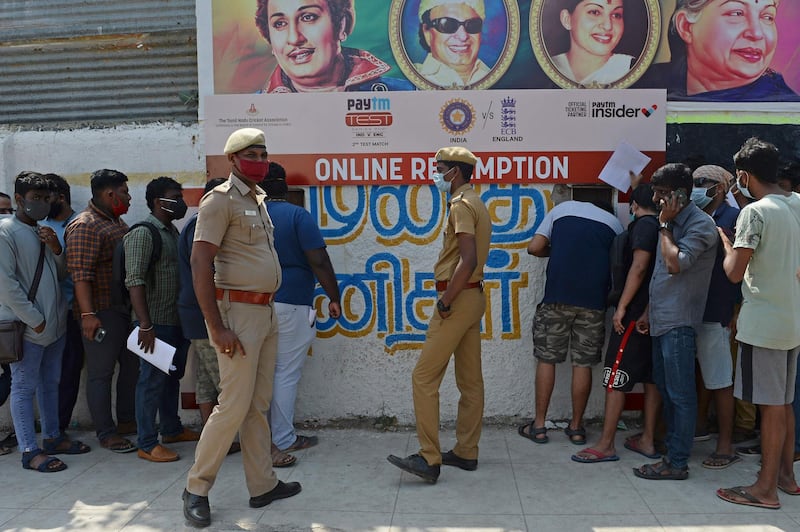Police stand as cricket fans queue to collect their tickets for second Test at the M.A. Chidambaram Stadium. AFP