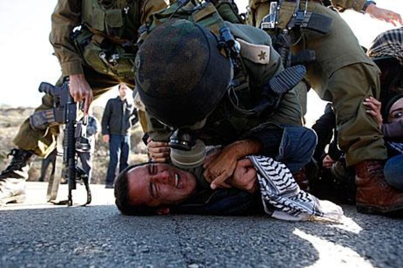 Israeli soldiers detain an activist in the West Bank village of Nabi Saleh yesterday.