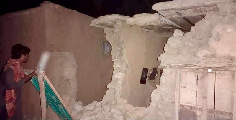 A man inspects his damaged house following a severe earthquake in Harnai, about 100 kilometres from Quetta, Pakistan. AP