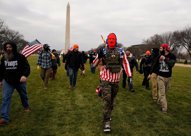 FILE - In this Jan. 6, 2021, file photo, people march with those who say they are members of the Proud Boys as they attend a rally in Washington in support of President Donald Trump. In its annual report set to be released Monday, Feb. 1, 2021, the Southern Poverty Law Center said it identified 838 active hate groups operating across the U.S. in 2020. The SPLCâ€™s report comes out nearly a month after a mostly white mob of Trump supporters and members of far-right groups violently breached the U.S. Capitol building. (AP Photo/Carolyn Kaster, File)