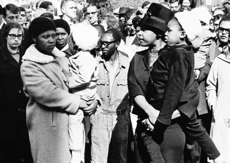 June 12, 1964: Winnie Mandela, right, waits in vain for a glimpse of her husband, Nelson Mandela, outside the Palace of Justice in Pretoria. AP Photo