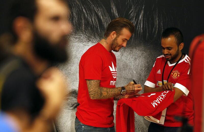 Footballing legend David Beckham signs a jersey for a fan following his arrival at Mall of the Emirates. Karim Sahib / AFP