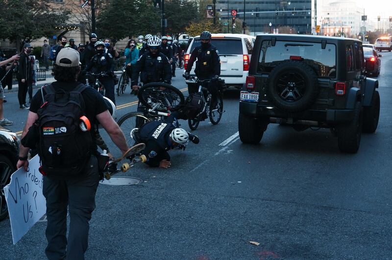 A bike patrol police officer falls to the ground after crashing into a truck with Trump supporters trying to run anti-Trump protesters, in Massachusetts Avenue, in Washington, DC, US.  EPA