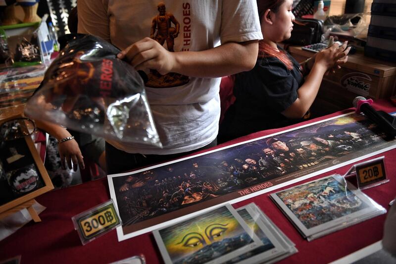 This picture shows vendors selling memorabilia, illustrating the rescue of the 12 boys from the "Wild Boars" football team and their coach. AFP