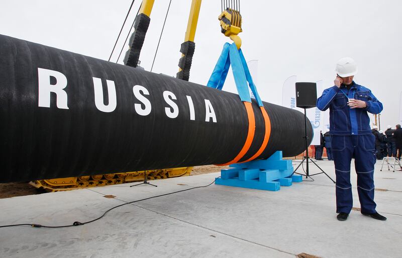 A Russian construction worker speaks on a mobile phone during a ceremony marking the construction of the Nord Stream pipeline in Portovaya Bay, 170 kilometres north-west of St Petersburg in Russia. AP Photo