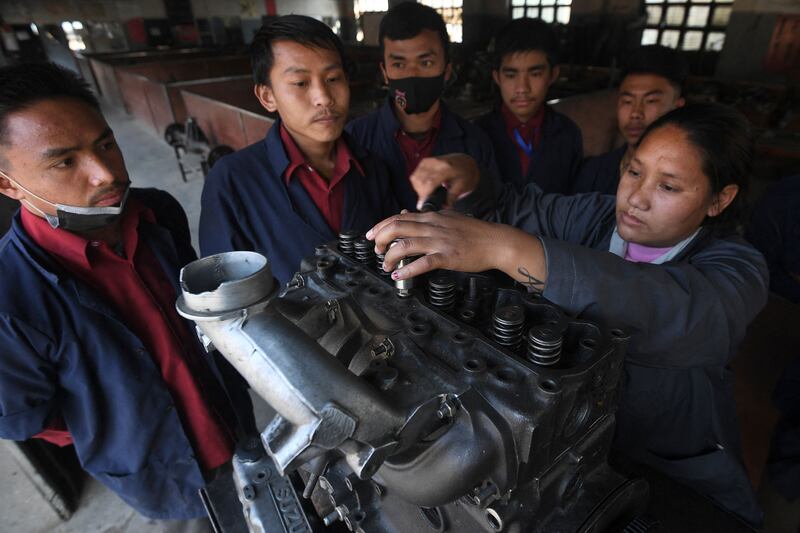 A female mechanic teaches students about car engines, as part of the Underprivileged Children's Educational Programmes, on the outskirts of Kathmandu, Nepal.  AFP