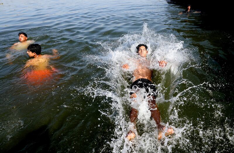 Boys swim in the Nile amid a heatwave at El Qanater El Khairiyah. Reuters