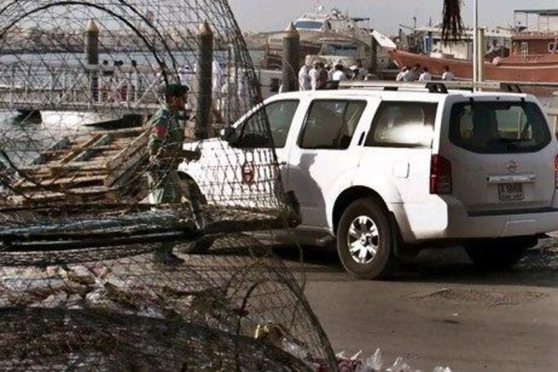 Emirati police and other officials inspect a fishing boat that was shot at by the crew of a United States navy vessel. One fisherman was killed and three other men critically injured.