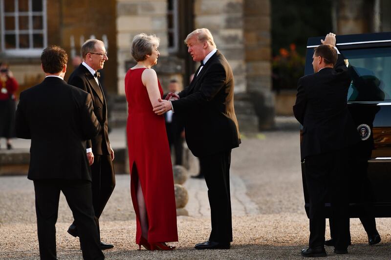 Ms May, centre left, shakes hands with Mr Trump, as her husband Philip, second left, looks. AP