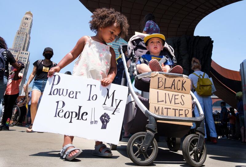 Uma Sarre, 3, left, and Samson Geller, 2, hold signs as families gather for a children's protest  in New York.  EPA