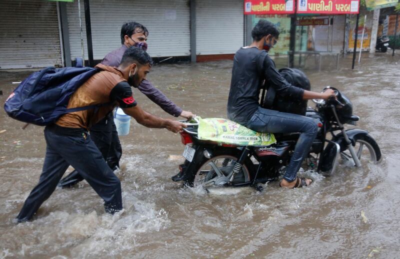 Three men navigate a flooded street in Ahmedabad after Cyclone Tauktae struck. The storm was the most powerful to hit the region in more than two decades. AP Photo