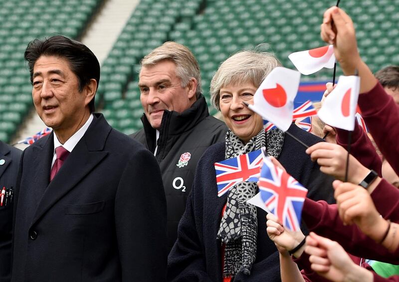 epa07273065 British Prime Minister Theresa May (R) and Prime Minister Shinzo Abe of Japan (L) react as they meet children in Twickenham stadium in London, Britain, 10 January 2019. The Prime Ministers met kids from a 'CBRE all schools programme' which is a RUF initiative to help children from states schools to play more rugby.  EPA/FACUNDO ARRIZABALAGA