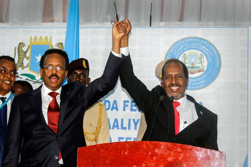 Hassan Sheikh Mohamud (R), marking his election win with incumbent leader Mohamed Abdullahi Mohamed in Mogadishu, Somalia, has returned to the nation's top office. AP Photo