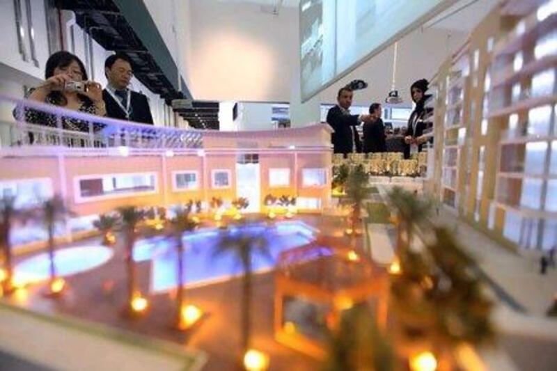 Visitors look at an Eshraq model on display yesterday Cityscape in Abu Dhabi.