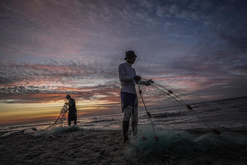 Palestinian fishermen prepare their fishnets in the Mediterranean Sea during sunset in Gaza City. EPA