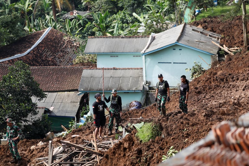 Army officers help to evacuate people in Cugenang, Cianjur. Reuters