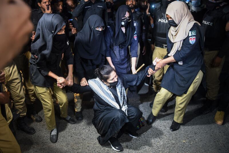 Policewomen detain a supporter of Mr Khan in Karachi during a protest against his arrest. AFP