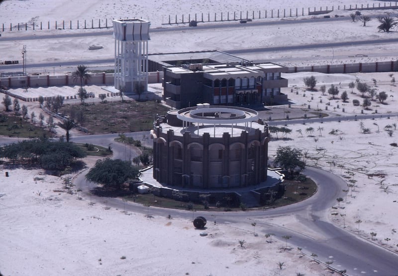 Signed into effect on December 2, 1971, the original constitution of the UAE only designated Abu Dhabi as a temporary capital.
It was envisaged that it would eventually hand over to  a new city to be called Karama that would be built on the border of Abu Dhabi and Dubai.
While Karama was planned, Abu Dhabi went ahead with the construction of many buildings that would, for at least a while, serve as the institutions of government.
They include this complex, photographed in 1975 by Alain Saint Hilaire. Each of the seven rulers would have a building to serve as their secretariat, one of which can be seen here, next to the water tower.
The circular building was built in the late 1960s to serve as a meeting place for the Rulers as they discussed the new federation. According to Time FrameÕs sources, it was later used for public lectures organised by the Ministry of Foreign Affairs.
Only four of the seven buildings were eventually finished. Some of these structures, along with the water tower, still remain on the site, at the end of Zayed the First Street just before the junction of King Abdullah bin Abdulaziz Al Saud Street in the Al Khubairah district. Sadly the round meeting place that hosted so many historic meetings has been demolished.
Karama, of course, was never built and Abu Dhabi ,in time, designated the official UAE capital. There is one reminder of those original plans still with us. The new capital was designated 01 in the new national telephone system, which is why phone numbers in Abu Dhabi begin with 02 to this day.