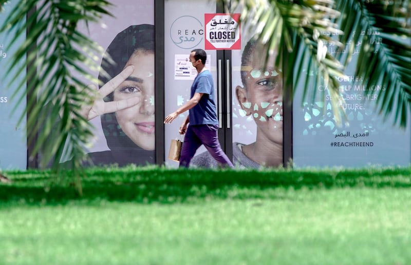 Abu Dhabi, United Arab Emirates, April 24, 2020.    
  A pedestrian walks pass a bus stop at downtown Abu Dhabi during the Coronavirus epidemic.
Section:  NA
For:  Standalone/Stock Images
