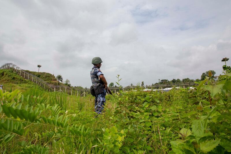 (FILES) In this file photo taken on August 24, 2018 Myanmar border guard police patrol the fence in the "no man's land" zone between Myanmar and Bangladesh border as seen from Maungdaw, Rakhine state during a government-organized visit for journalists on August 24, 2018. Panic is gripping thousands of Rohingya Muslim refugees living in no-man's land on the Myanmar-Bangladesh border, with daily clashes between Myanmar security forces and ethnic Rakhine insurgents. / AFP / Phyo Hein KYAW
