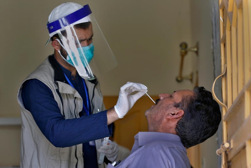 A health worker takes a nasal swab sample of a person during door-to-door testing and screening facility for the new coronavirus, in Islamabad, Pakistan, Monday, June 15, 2020. (AP Photo/Anjum Naveed)