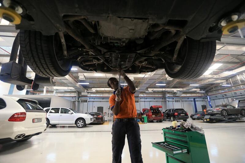 A mechanic works on a Porsche at JZM Gulf’s workshop in the Mussaffah industrial zone. Ravindranath K / The National