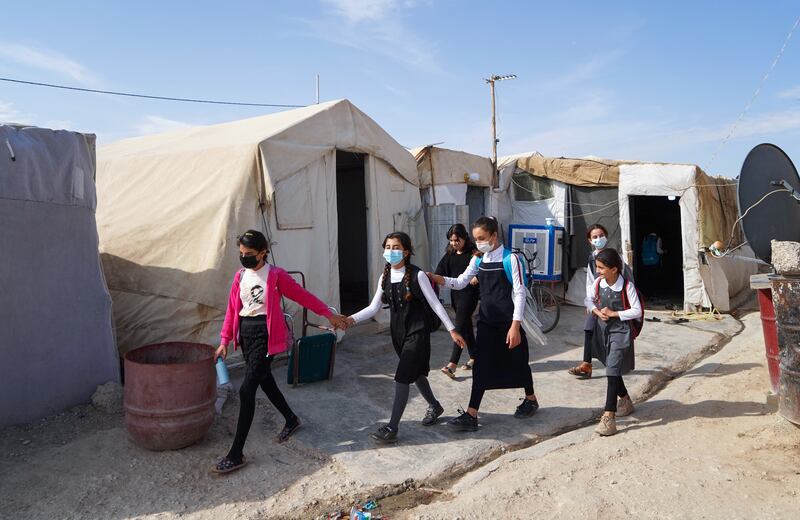 Girls walk to class on the first day of school in a camp for displaced Yazidi people in the Sharya area, about 15 kilometres from Dohuk, in the autonomous Iraqi Kurdistan region.