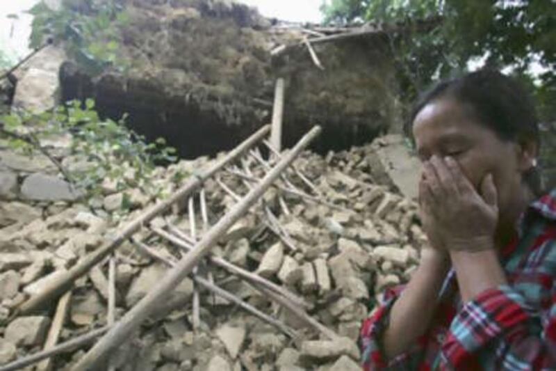 Zhang Mingyu, 41, cries in front of her house, which was destroyed during an aftershock in Yuanmou County, Yunnan province, on Sunday.