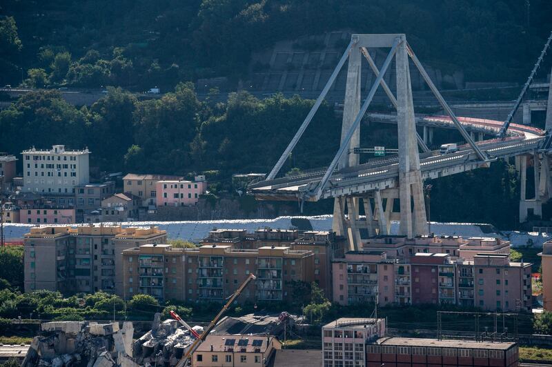 Residential buildings stand near the rubble from the section of the Morandi motorway bridge after it partially collapsed in Genoa, Italy, on Wednesday, Aug. 15, 2018. The Italian government called on managers at Atlantia Spa's highway-operator unit to resign following the collapse of the bridge that killed at least 37 people. Photographer: Federico Bernini/Bloomberg