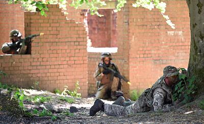 A British soldier, right, and Ukrainians take part in urban combat exercises at a military base in Northern England. AFP