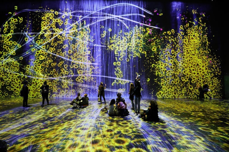 People enjoy the Teamlab show, an interactive digital show created by an interdisciplinary group of artists, engineers, 3D creators, mathematicians, architects and web designers at the Grande Halle de la Villette exhibition hall on May 15, 2018 in Paris. (Photo by Ludovic MARIN / AFP) / RESTRICTED TO EDITORIAL USE - MANDATORY MENTION OF TEAMLAB UPON PUBLICATION - TO ILLUSTRATE THE EVENT AS SPECIFIED IN THE CAPTION