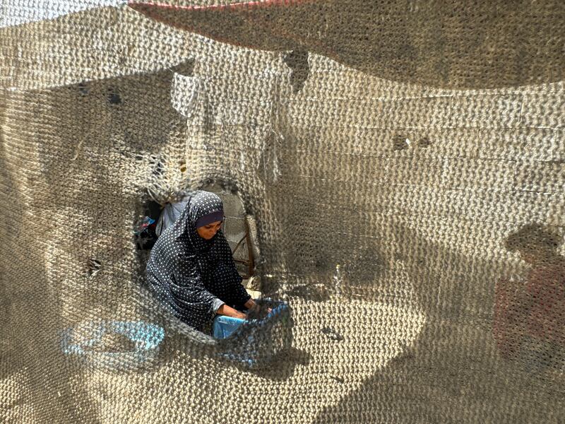 A displaced Palestinian woman washes clothes at a tent camp in Rafah, southern Gaza. Reuters