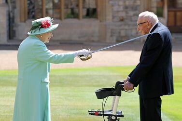 Britain's Queen Elizabeth awards Captain Tom Moore with the insignia of Knight Bachelor at Windsor Castle. Reuters