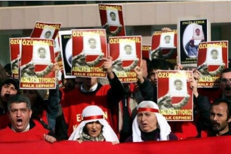 Family members and friends hold up posters of political activist Engin Ceber. A prison director and two guards have been convicted for their involvement in his torture and death in custody.