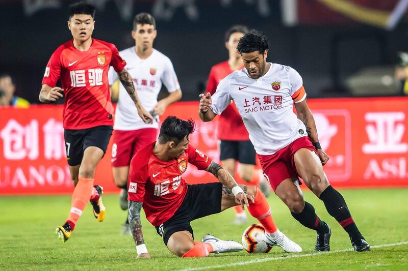 Shanghai SIPG's Hulk (R) fights for tha ball with Guangzhou Evergrande's Zhang Linpeng (C) during the Chinese Super League (CSL) football match between Guangzhou Evergrande and Shanghai SIPG in Guangzhou in China's southern Guangdong province on November 23 ,2019. China OUT
 / AFP / STR
