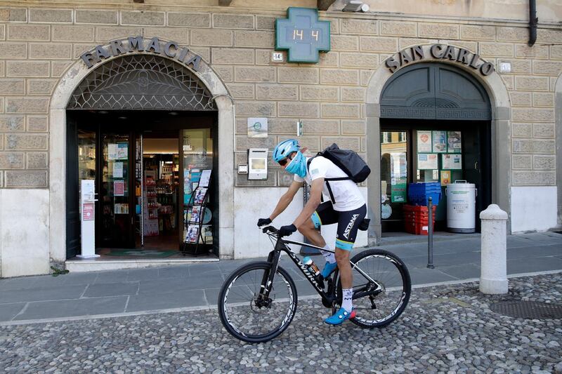 Davide Martinelli,rides his bike after collecting medicine at a pharmacy to be delivered to residents in Rovato, near Brescia, Northern Italy. AP Photo