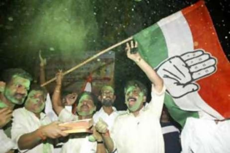 Congress party activists celebrate and wave an Indian National Congress flag, after the Congress-led United Progressive Alliance government won the vote of confidence.